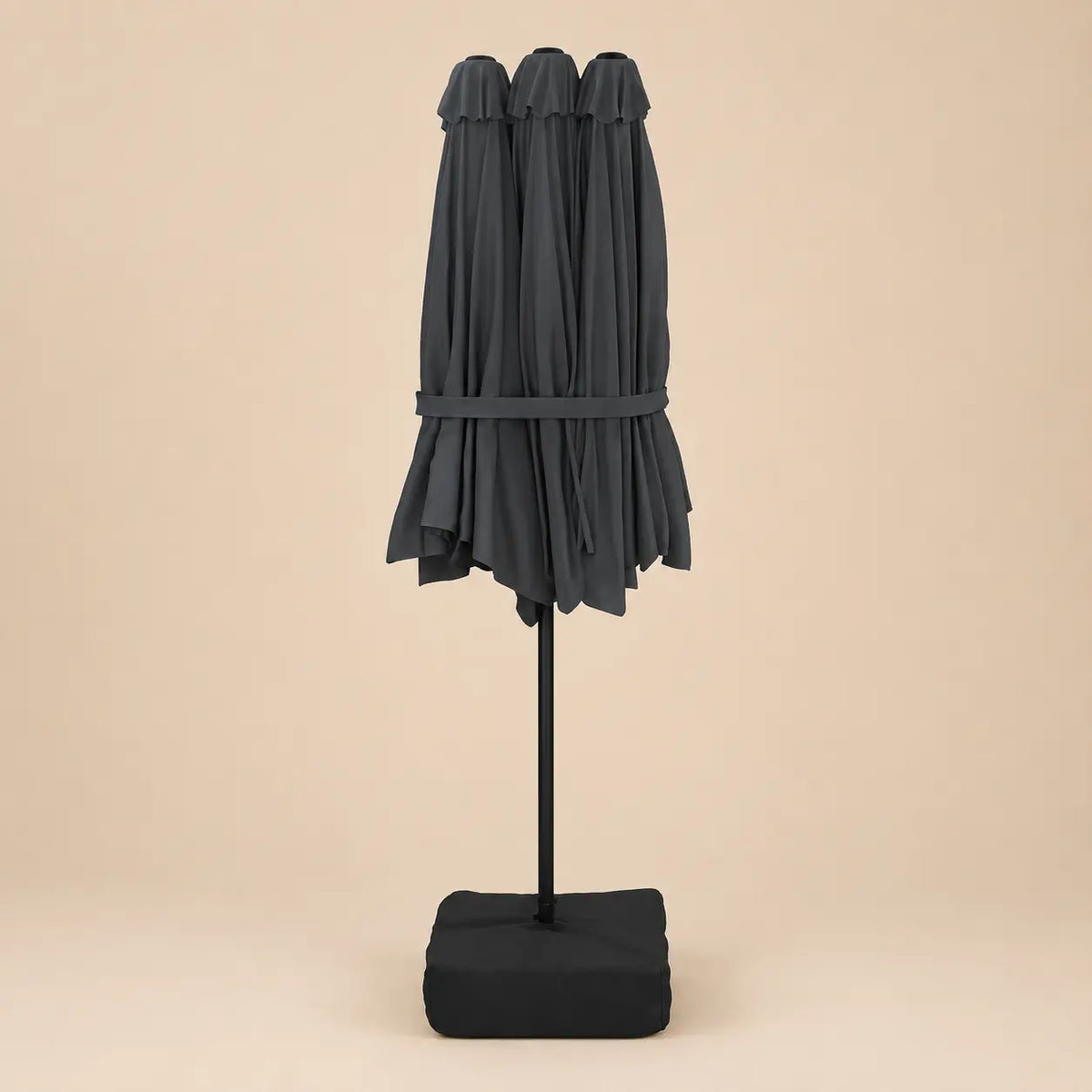Anthracite double canopy market umbrella folded closed on black aluminium pole with square weighted base