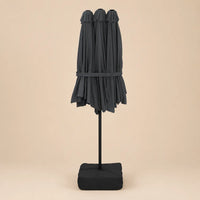 Anthracite double canopy market umbrella folded closed on black aluminium pole with square weighted base