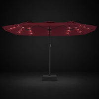 Bordeaux double canopy market umbrella with integrated LED lights illuminated at night on a dark background