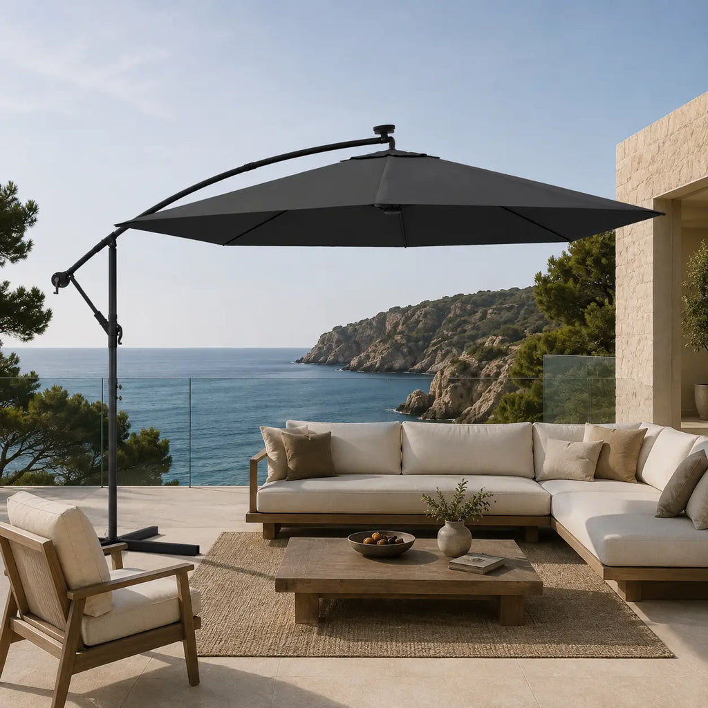 Round cantilever umbrella 3m Anthracite shading outdoor sectional sofa on coastal terrace with glass railing – Libeccio