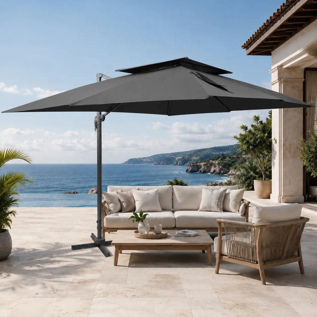 Anthracite rectangular cantilever umbrella providing shade over an outdoor sofa setting on a coastal limestone terrace