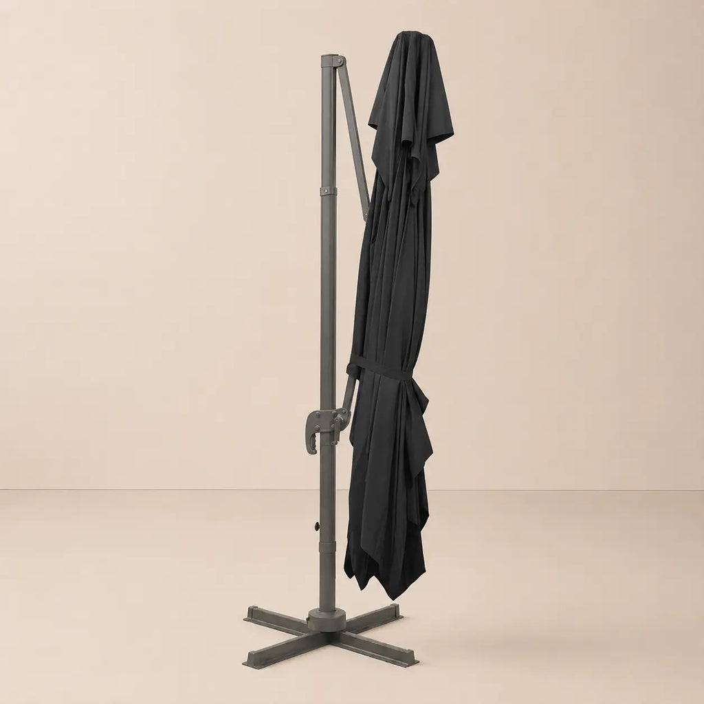 Mistral XL black rectangular cantilever umbrella folded and secured with fabric tie strap for compact storage