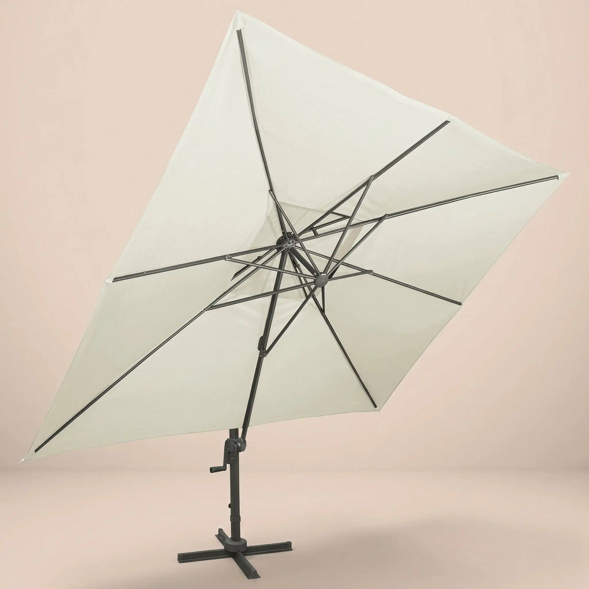 Underside view of the tilted rectangular cantilever umbrella showing the reinforced aluminium rib frame and ivory canopy
