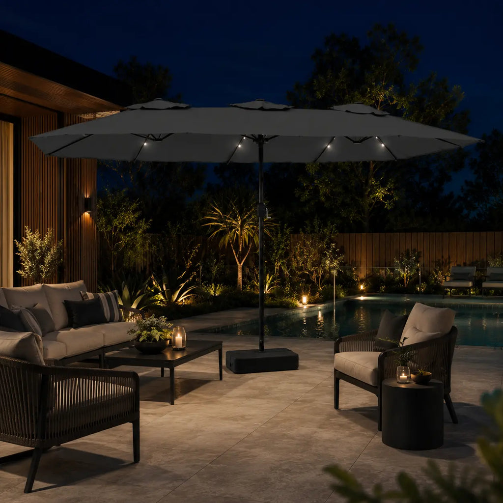 Large anthracite double canopy market umbrella with LED lights over an outdoor lounge area beside a pool at night