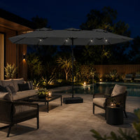 Large anthracite double canopy market umbrella with LED lights over an outdoor lounge area beside a pool at night
