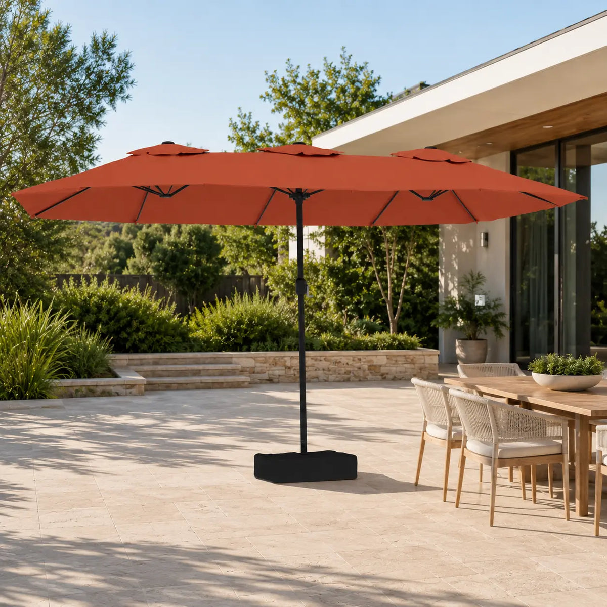 4.5m terracotta double canopy market umbrella shading a timber outdoor dining table in a garden alfresco setting