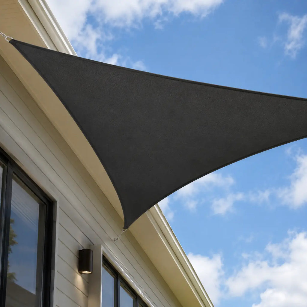 Anthracite triangular shade sail installed on an Australian home exterior facade with stainless steel chain fixings against a blue sky