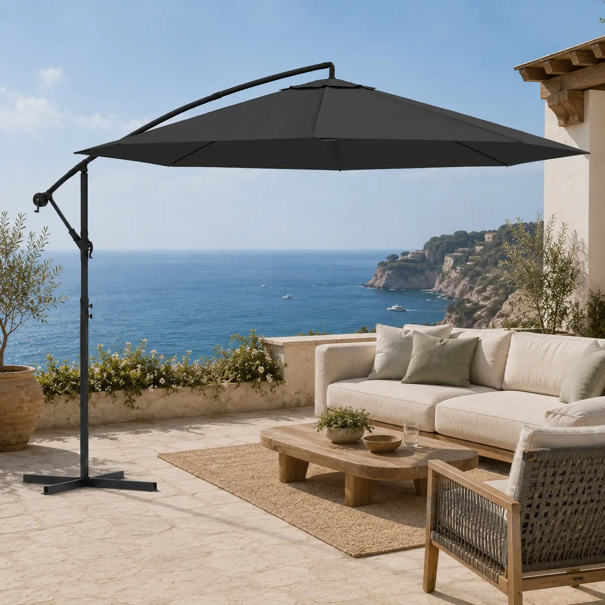 Round cantilever umbrella 3.5m Black shading outdoor lounge on coastal stone terrace with sea view – Ostro