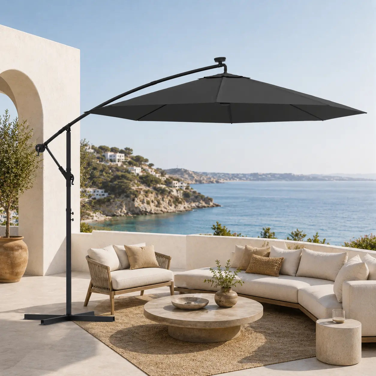 Round cantilever umbrella 3m Anthracite over curved outdoor sofa on villa patio with sea-view hillside – Libeccio