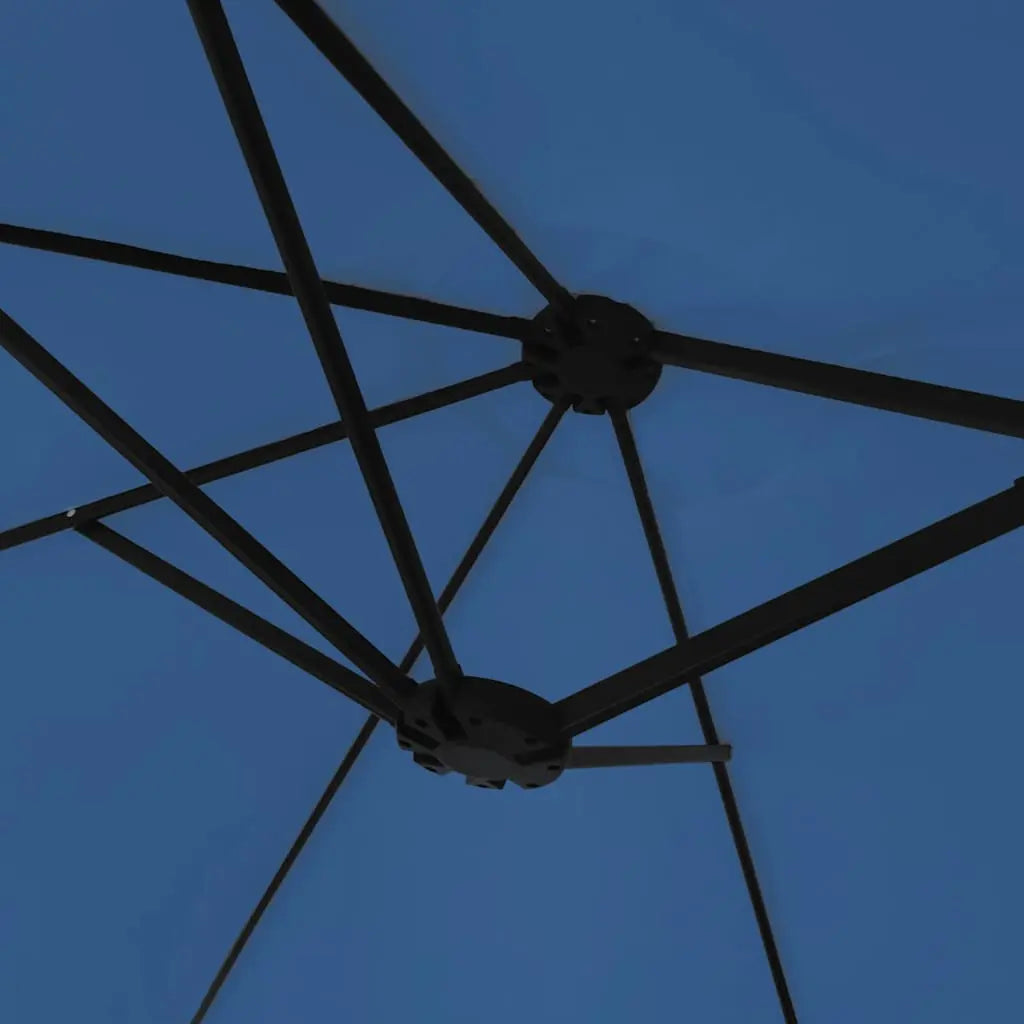 Underside view of an azure blue double canopy market umbrella showing black metal rib frame and dual hub junction