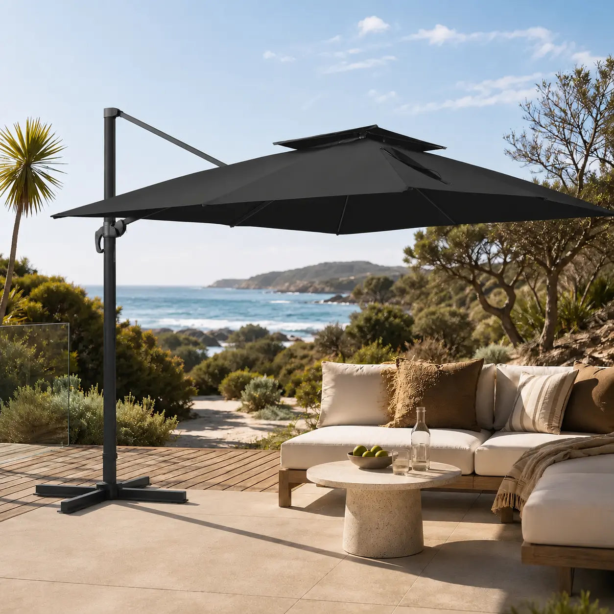 Black rectangular cantilever umbrella shading an outdoor lounge on a coastal timber deck with ocean view